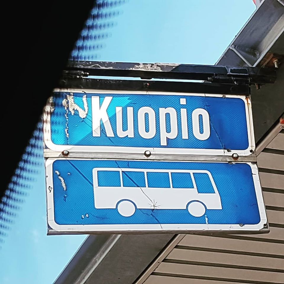 Bussipysäkin tunnus ja kyltti, missä lukee Kuopio.